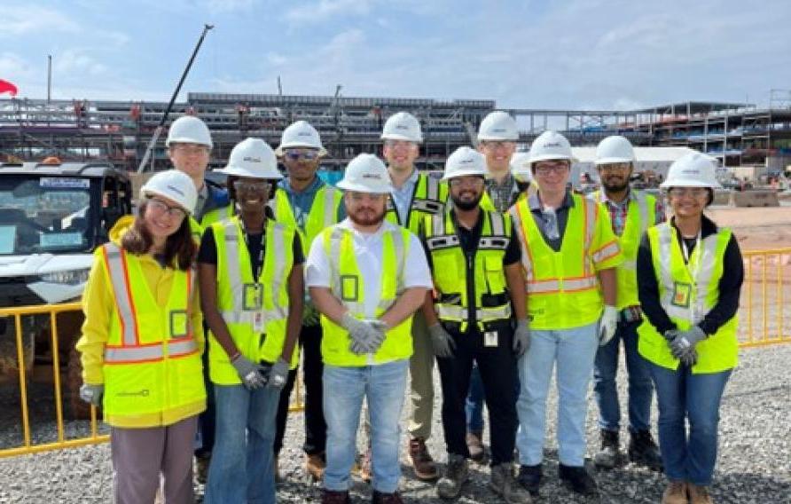 Jacobs interns in yellow PPE vests and white hardhats visit a project site